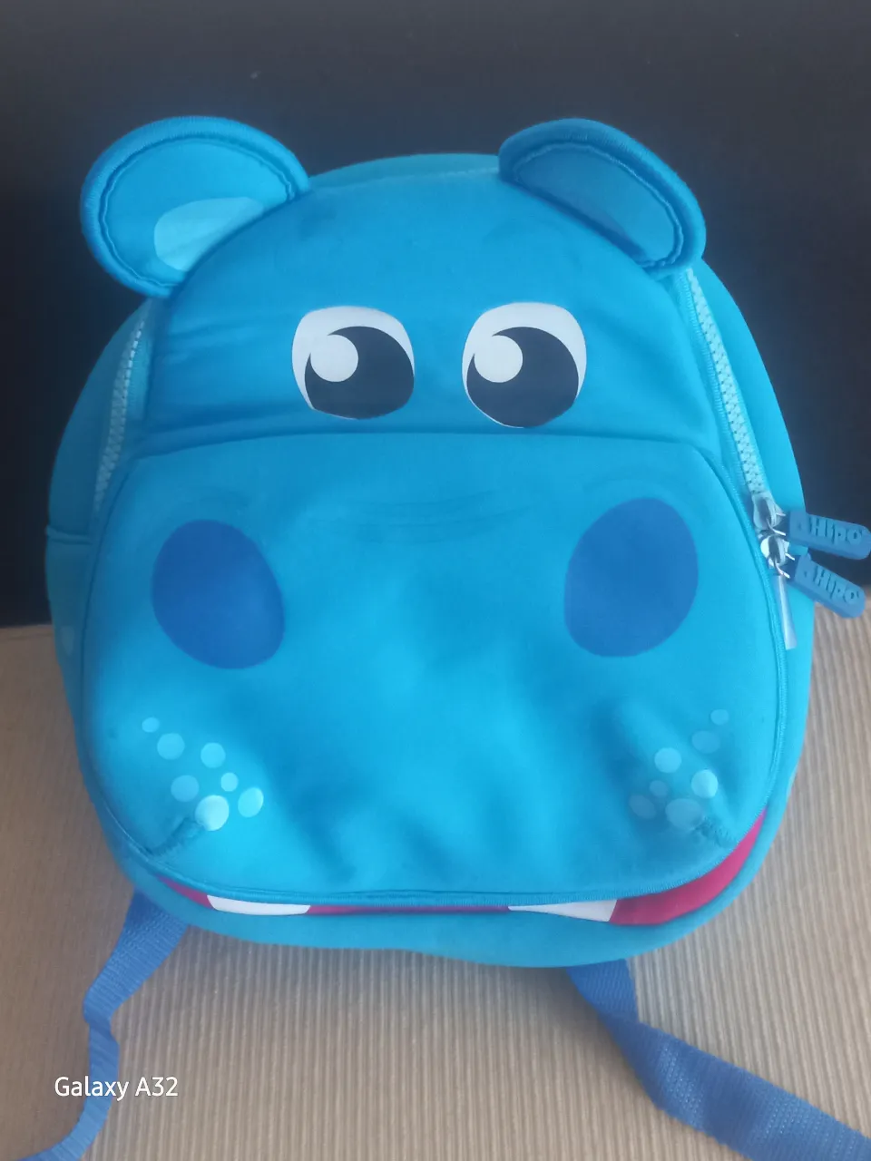 Mochila infantil con diseño de hipopótamo en color azul. Ideal para niños pequeños, con detalles como orejas y ojos en relieve. Cuenta con correas ajustables y un compartimento principal con cierre.
