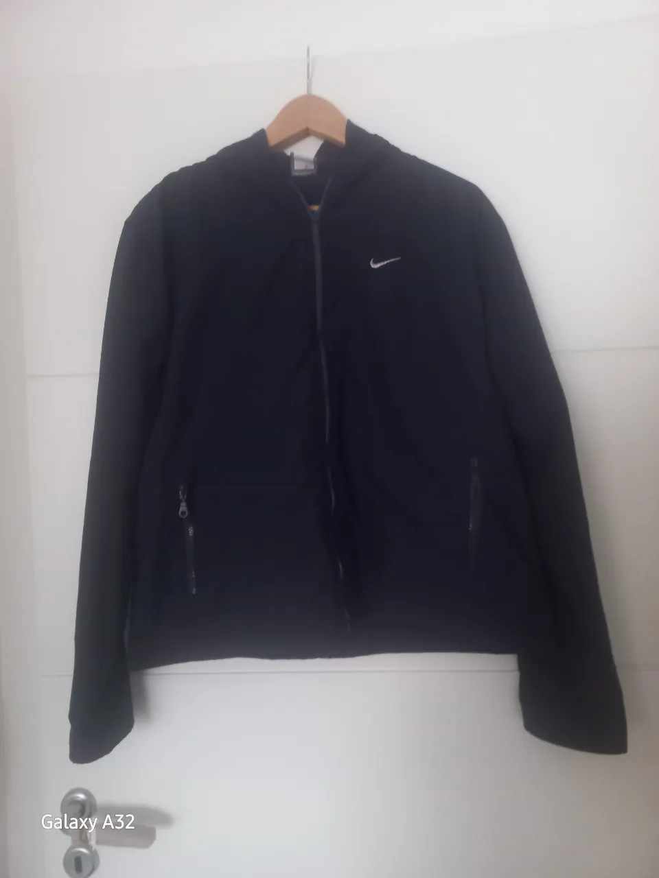 Campera deportiva Nike azul marino con cierre y capucha. Ideal para actividades al aire libre o uso casual. Posee dos bolsillos frontales con cierre y el logo de la marca en el pecho.