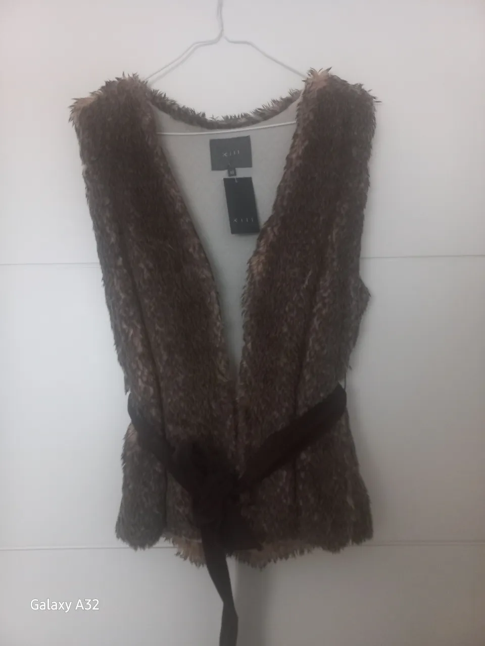 Chaleco de piel sintética marrón con cinturón. Ideal para un look elegante y abrigado.