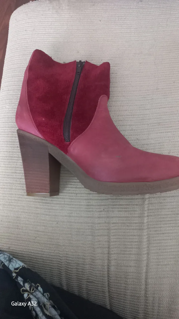 Botas de caña baja color rojo y rosa. Tienen cierre lateral y detalle de flecos en la parte externa. Taco grueso de madera.