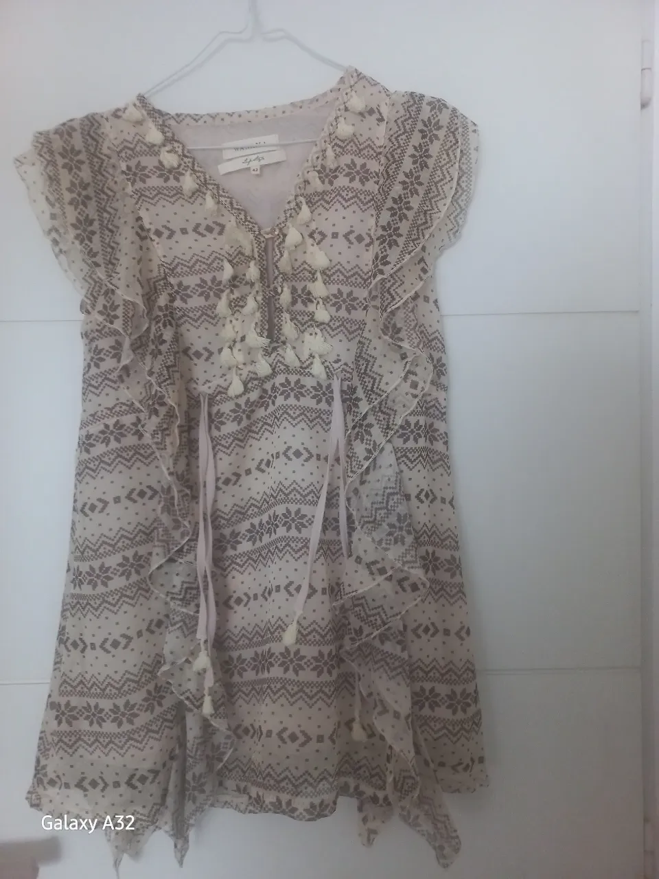 Blusa de mujer estilo boho, con estampado floral y detalles de borlas. Ideal para un look casual y fresco.