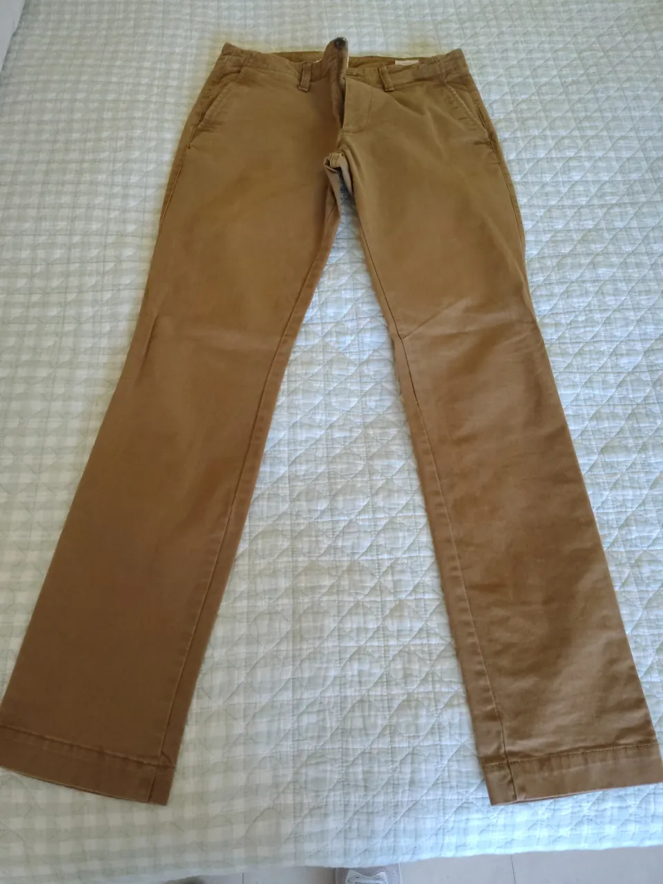 Pantalón de gabardina color marrón. Tiene bolsillos frontales y traseros.