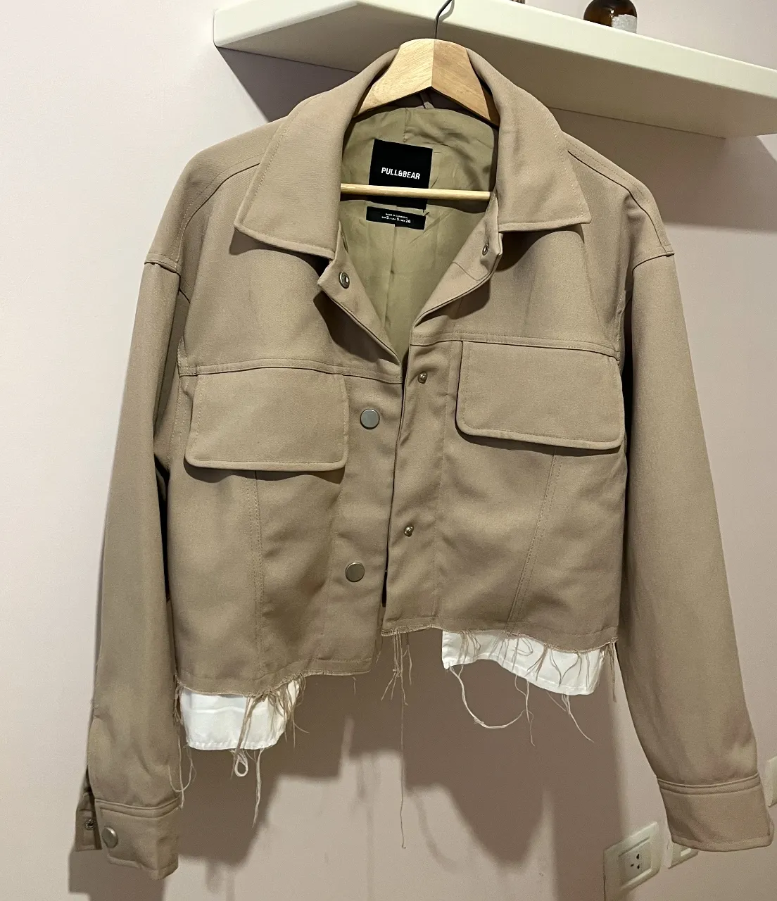 Campera estilo camisa de la marca Pull&Bear, color beige. Con detalles de flecos en la parte inferior y dos bolsillos delanteros. Tiene un solo uso!