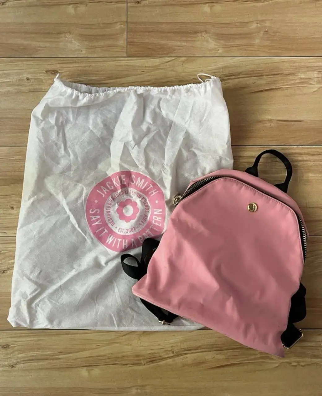 Mochila Jackie Smith rosa con detalles en negro. Tiene unas pequeñas manchas, lo demás está como nuevo.