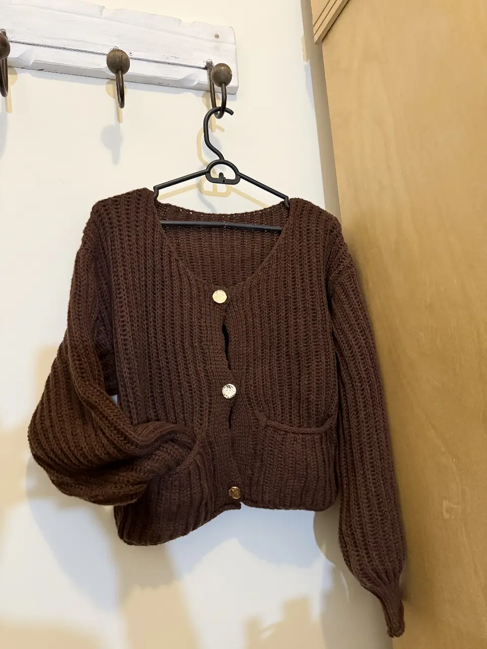 Cardigan de tejido grueso color marrón con botones dorados. Ideal para un look casual y abrigado.