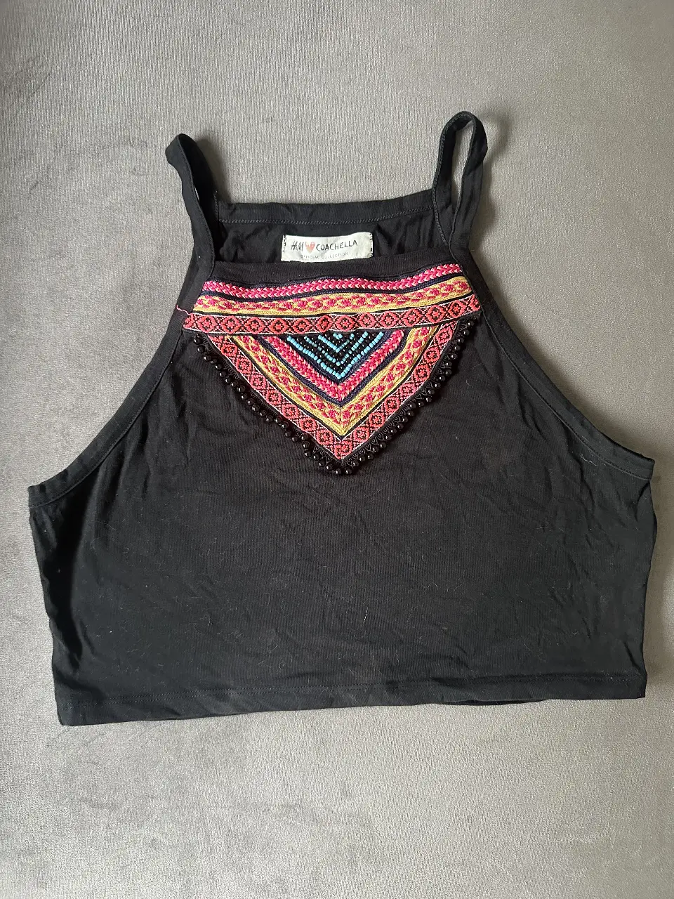 Top negro de H&M Coachella con detalle bordado en el frente. Ideal para festivales y eventos casuales.