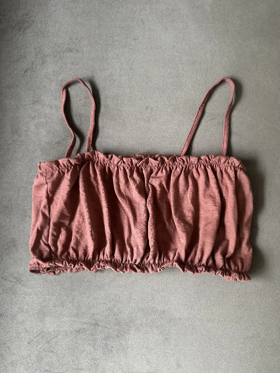 Top de mujer color marron, con breteles finos y detalle fruncido en el busto y cintura. 