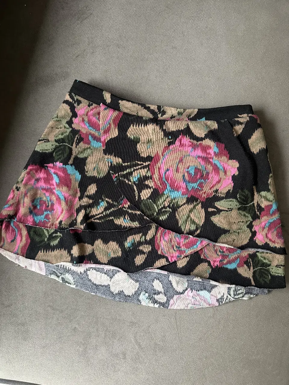 Pollera con estampado floral en tonos rosa, celeste y marrón sobre fondo negro. Talle 38. Marca: 47 Street