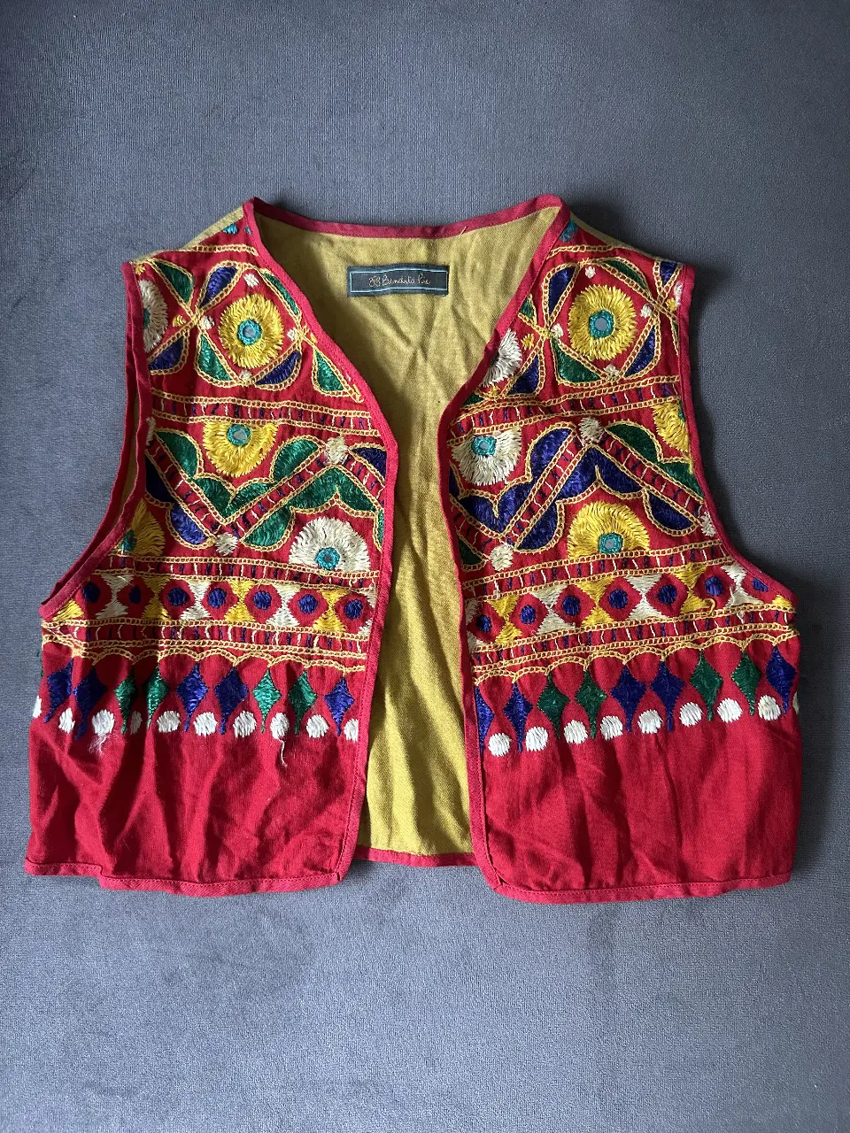 Chaleco bordado artesanal, estilo boho, con detalles multicolores. 