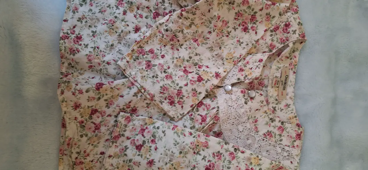 Camisa de niña con estampado floral en tonos rosas y blancos. Detalles de encaje en el cuello y botones. Ideal para un look romántico y delicado. talle 12 meses