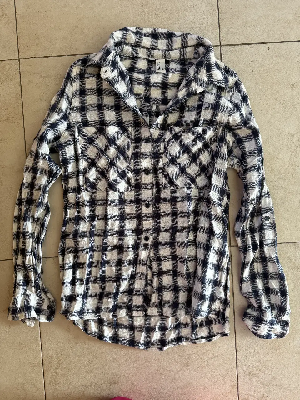 Camisa a cuadros en tonos blanco y azul, de manga larga con puños ajustables. Ideal para un look casual y versátil.