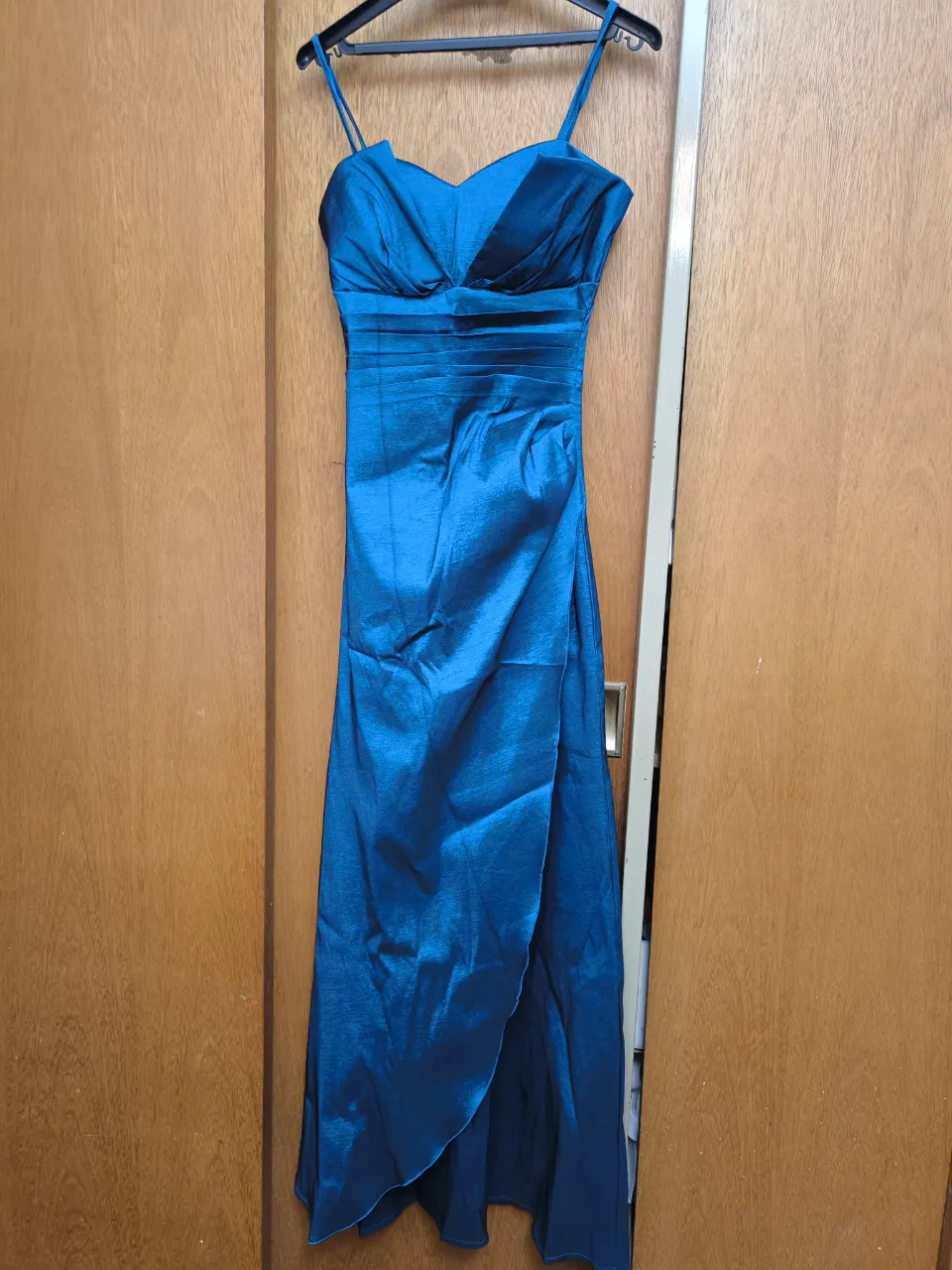 Vestido largo azul eléctrico, ideal para eventos formales o fiestas. Posee un escote corazón con drapeado y tirantes finos. La falda tiene una abertura lateral que le da un toque moderno y elegante. Cierre en la espalda.