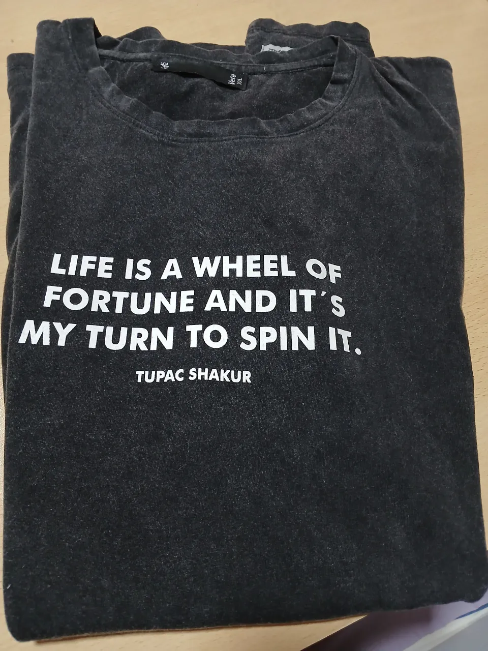 Remera de hombre de color gris con estampado de Tupac Shakur. La remera tiene una frase icónica del rapero y actor. Ideal para un look casual y urbano.