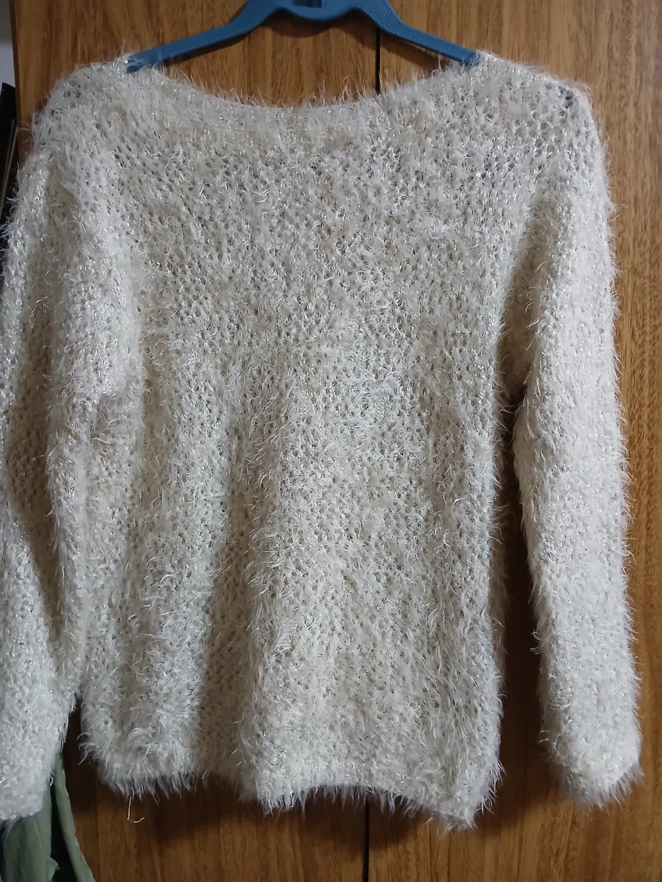 Sweater de mujer tejido en color blanco, con textura peluda y diseño en V. Ideal para un look casual y abrigado.