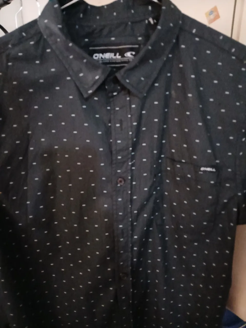 Camisa de manga corta con estampa de puntos blancos sobre fondo negro. Marca O'Neill, corte regular fit. Ideal para un look casual y moderno.