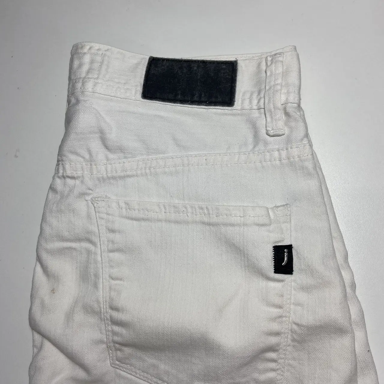 Minifalda de jean blanca, ideal para un look casual y fresco. Perfecta para combinar con diferentes tops y crear outfits versátiles.