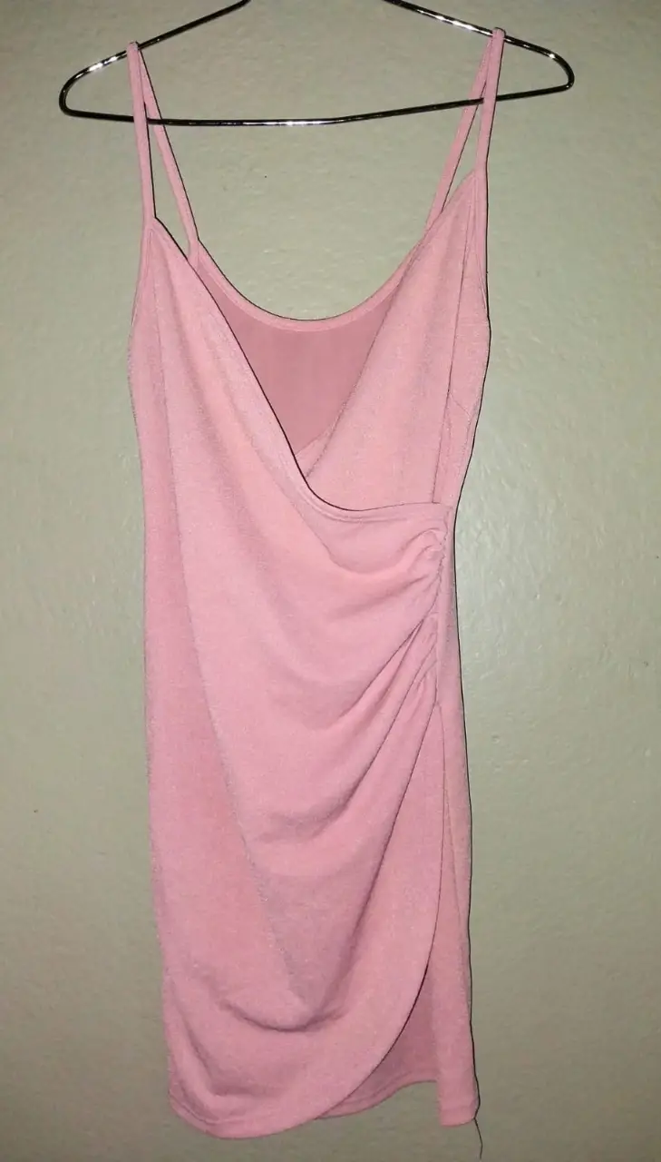 Vestido mini rosa, con escote en V y detalle drapeado en la cintura. Ideal para una salida o evento especial.