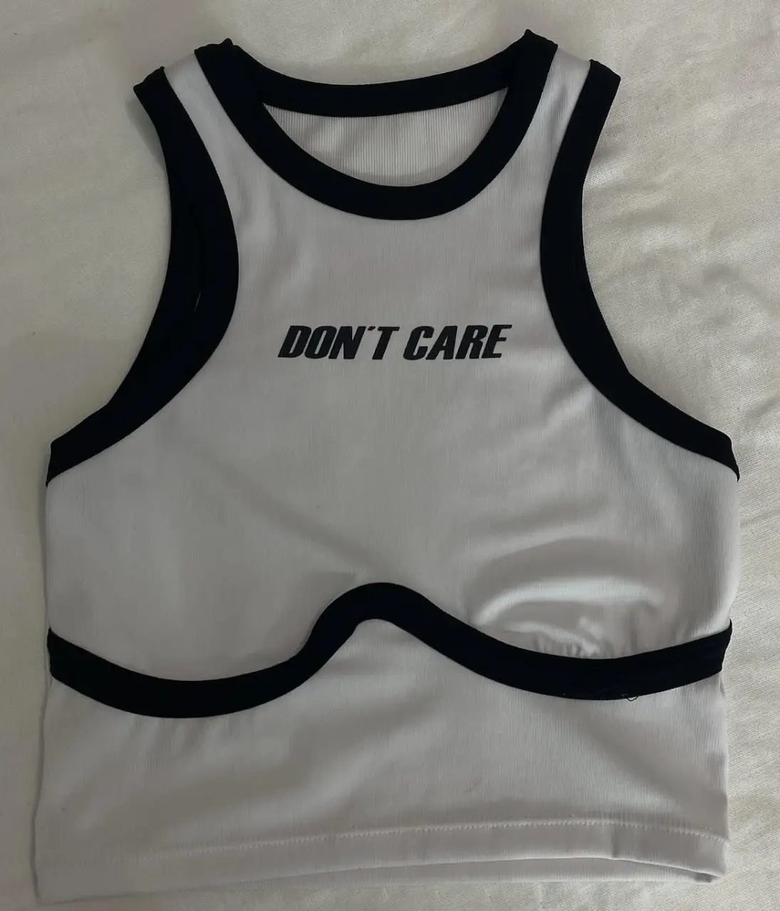 Top con detalles en negro y la frase "DON'T CARE".