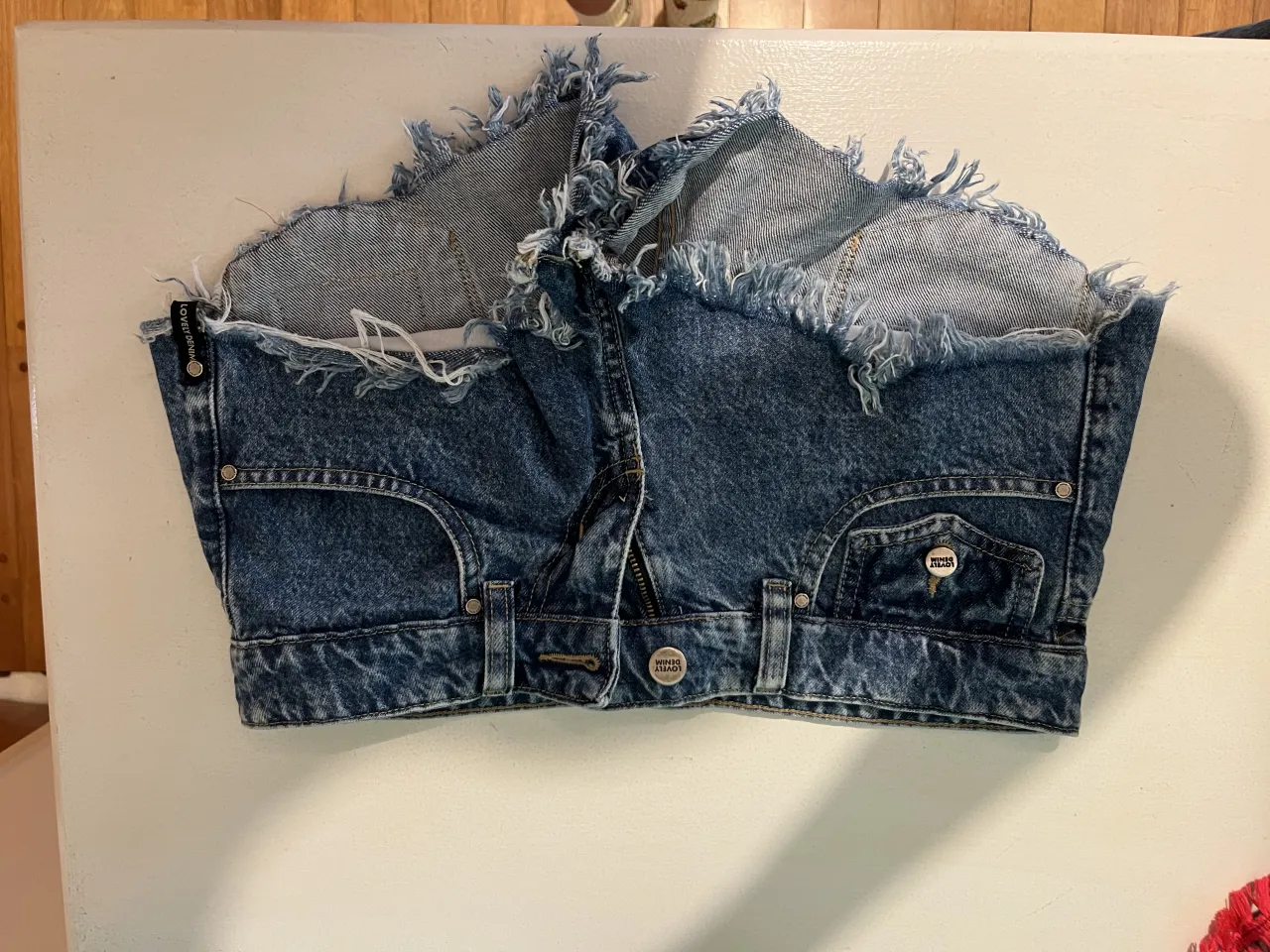 Shorts de jean tiro bajo de lovely denim con roturas y detalles desflecados en los bordes. Un clásico para lucir en cualquier ocasión informal.