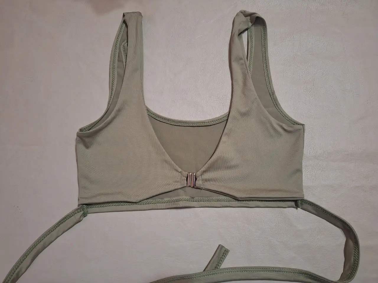 Top verde con diseño de espalda abierta y detalle de cierre frontal. Ideal para salir.