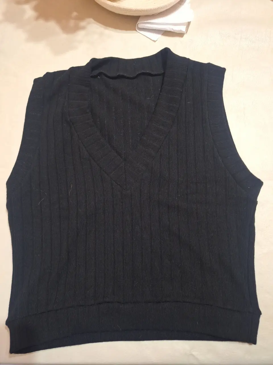 Chaleco tejido de punto, negro, con cuello en V. Ideal para un look casual y moderno.