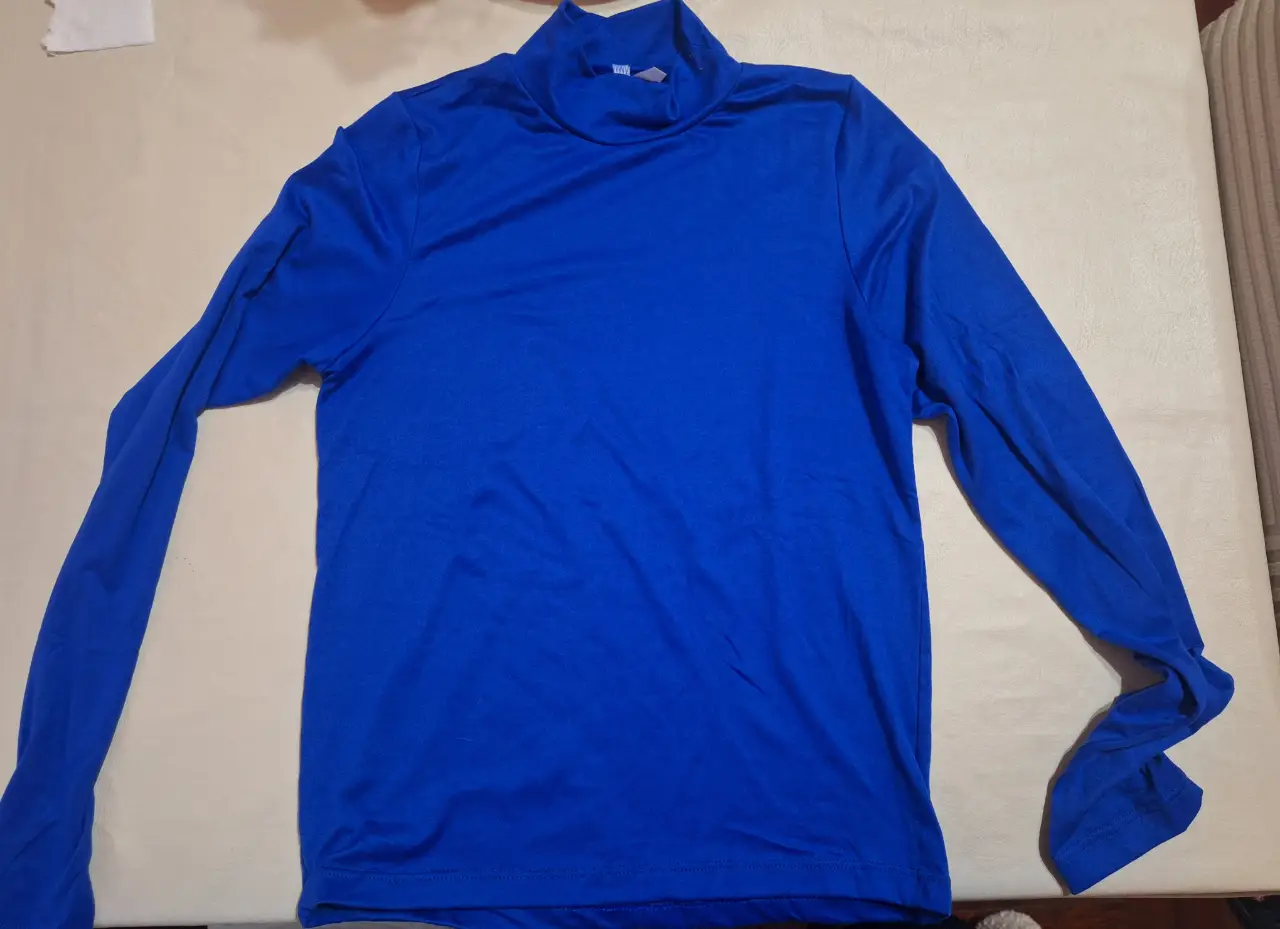 Remera manga larga azul con cuello alto, ideal para actividades deportivas o uso casual. Confeccionada en tela suave y cómoda.