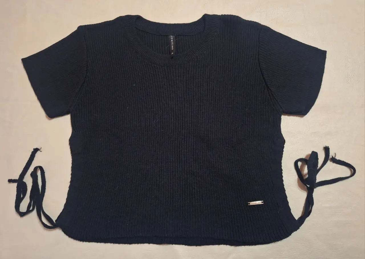 Remera de mujer de punto acanalado, con detalle de lazos en los laterales con abertura. Ideal para un look casual y moderno.