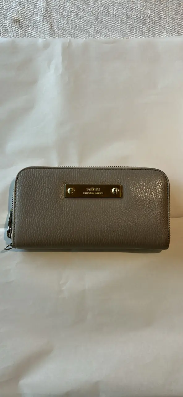 Billetera de mujer color gris, con cierre y detalles dorados. Interior con múltiples compartimentos para tarjetas y documentos, además de un bolsillo con cierre para monedas. Diseño elegante y funcional.