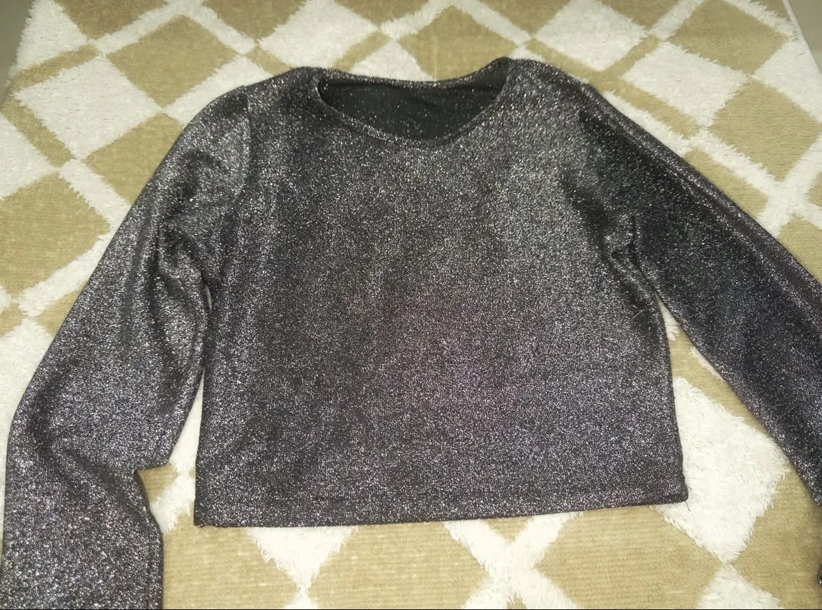 Remera manga larga plateada con brillos.