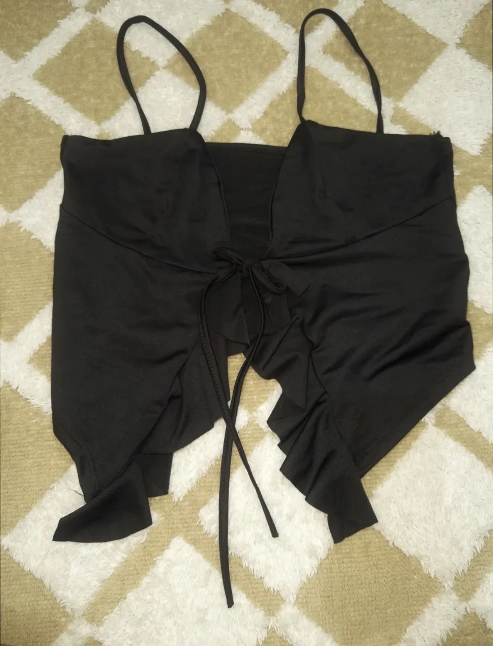 Top negro con tiras finas y lazo en el frente.