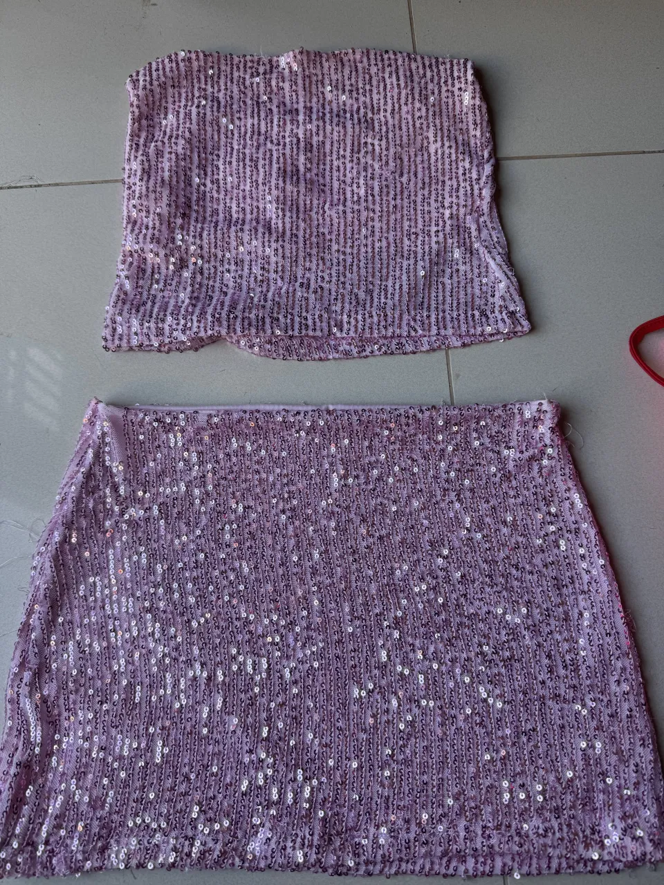 Conjunto de dos piezas: top strapless y pollera corta, ambos con lentejuelas rosas.