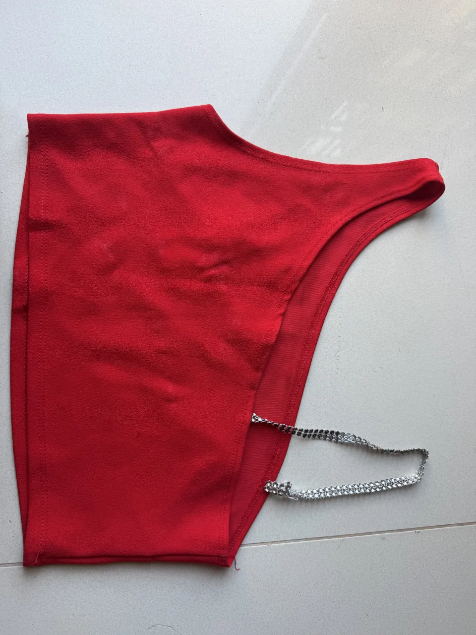 Body de lycra rojo con tiras de strass plateadas en los laterales.