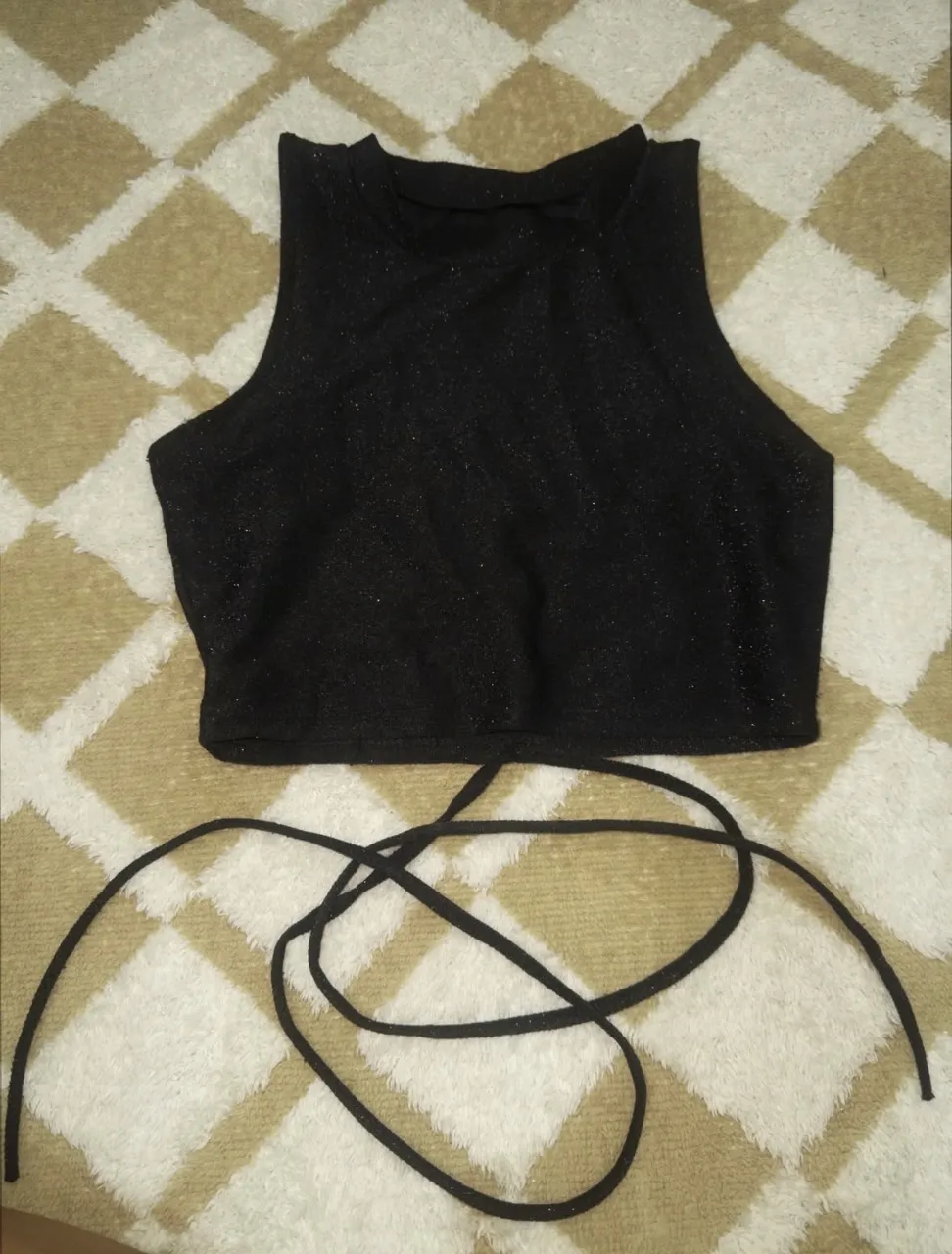 Top negro con brillos y tiras largas para atar en la espalda.