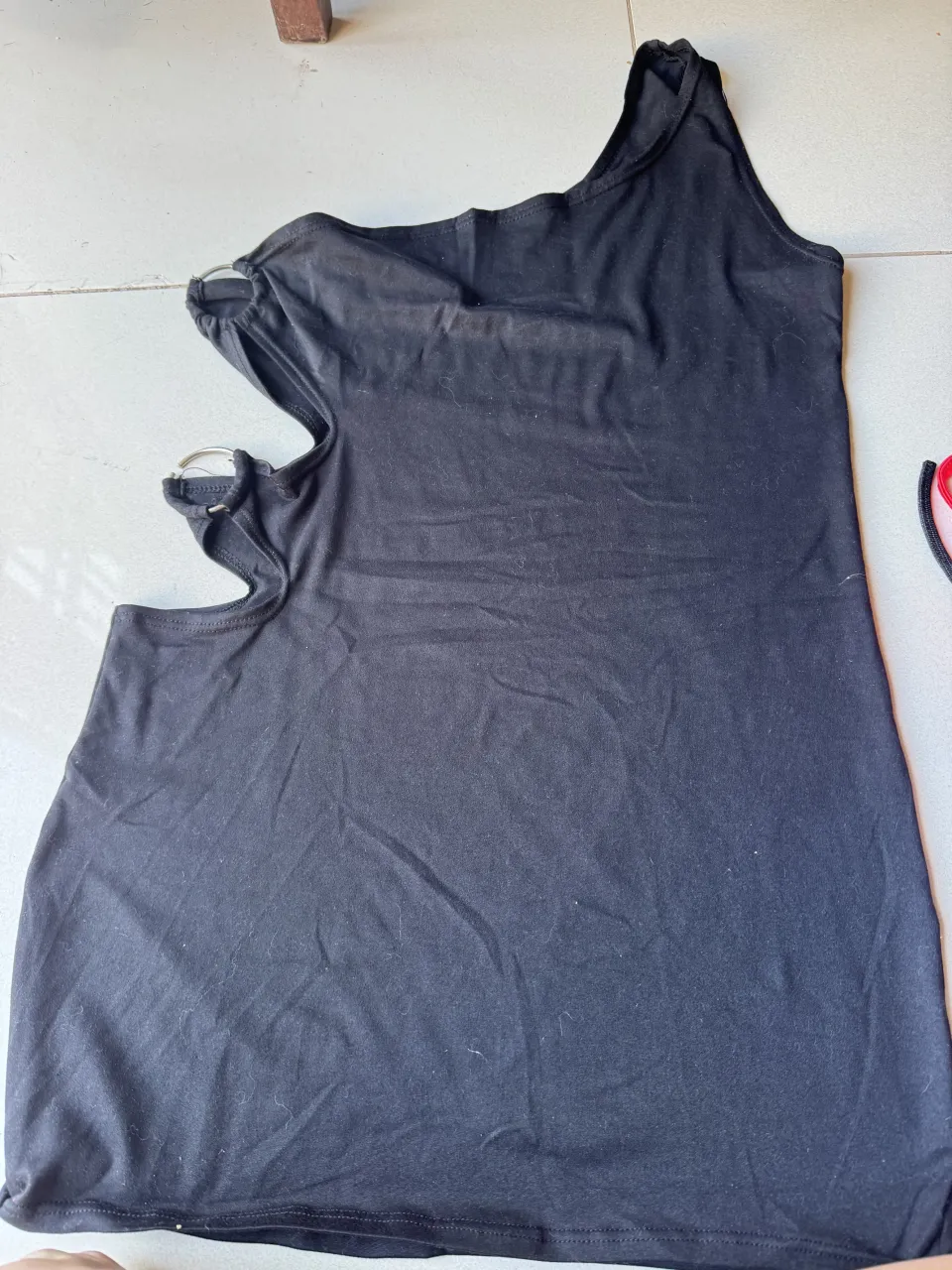 vestido asimétrico  negro de un solo hombro con detalles de argollas metálicas dos cortes en la panza