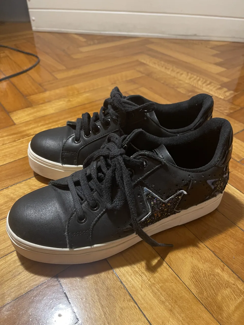 Zapatillas negras con detalles de estrella brillante y suela blanca
Marca Sarkany
Talle 36