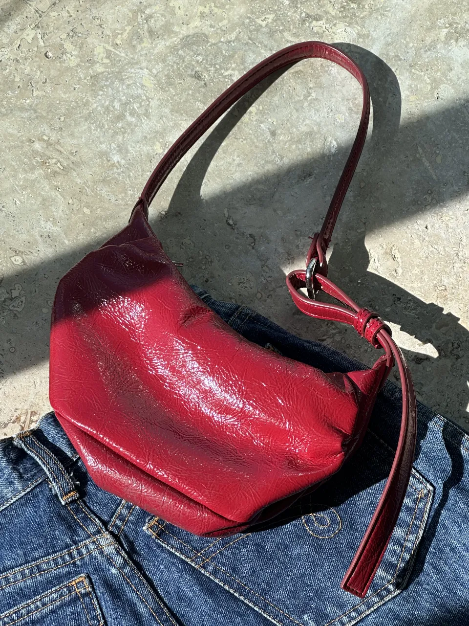 Cartera bandolera roja de charol, ideal para un look moderno y audaz. Perfecta para llevar lo esencial con estilo.