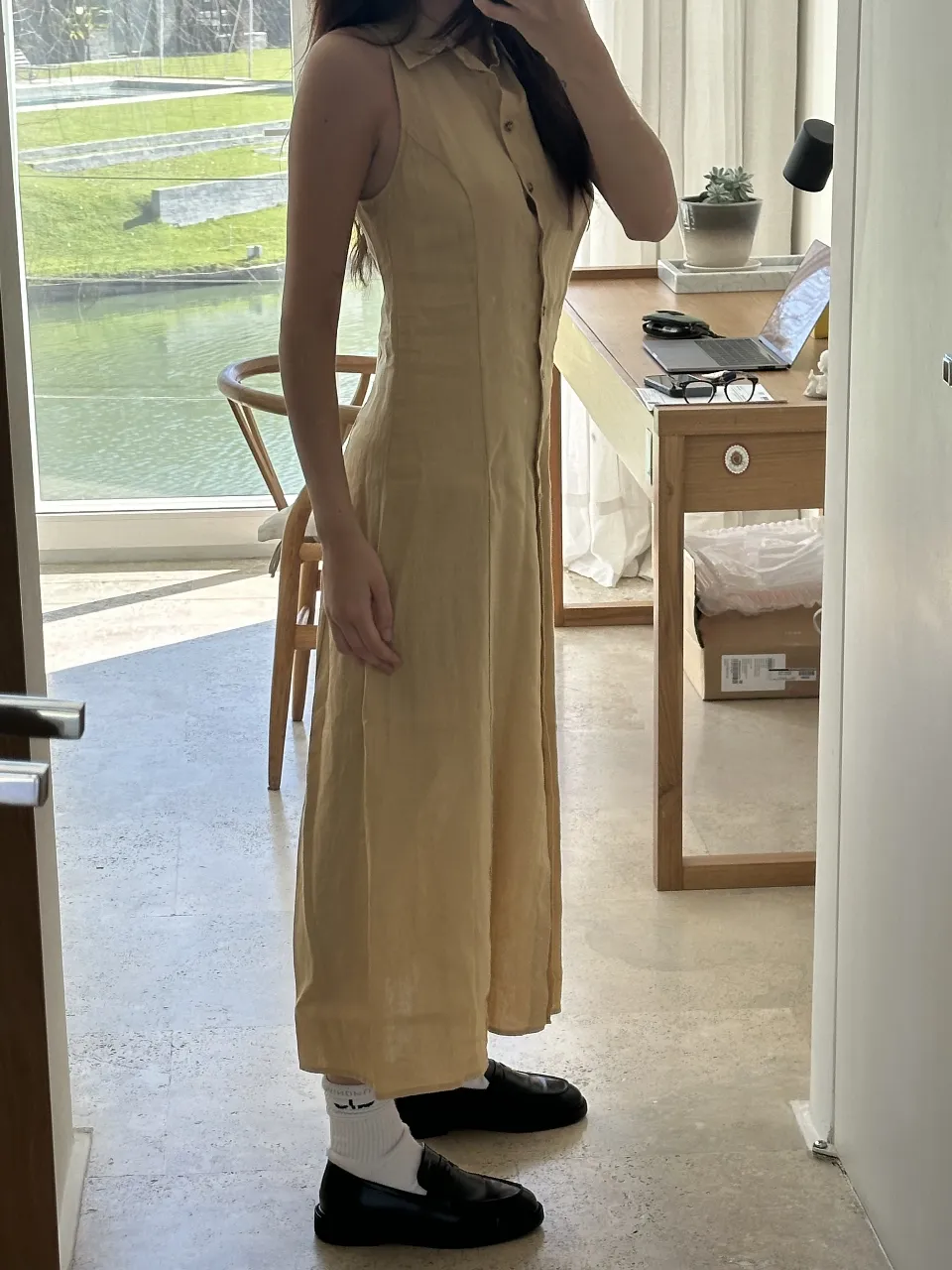Vestido midi de lino color amarillo, con cuello camisero y botones frontales. Ideal para un look fresco y elegante.