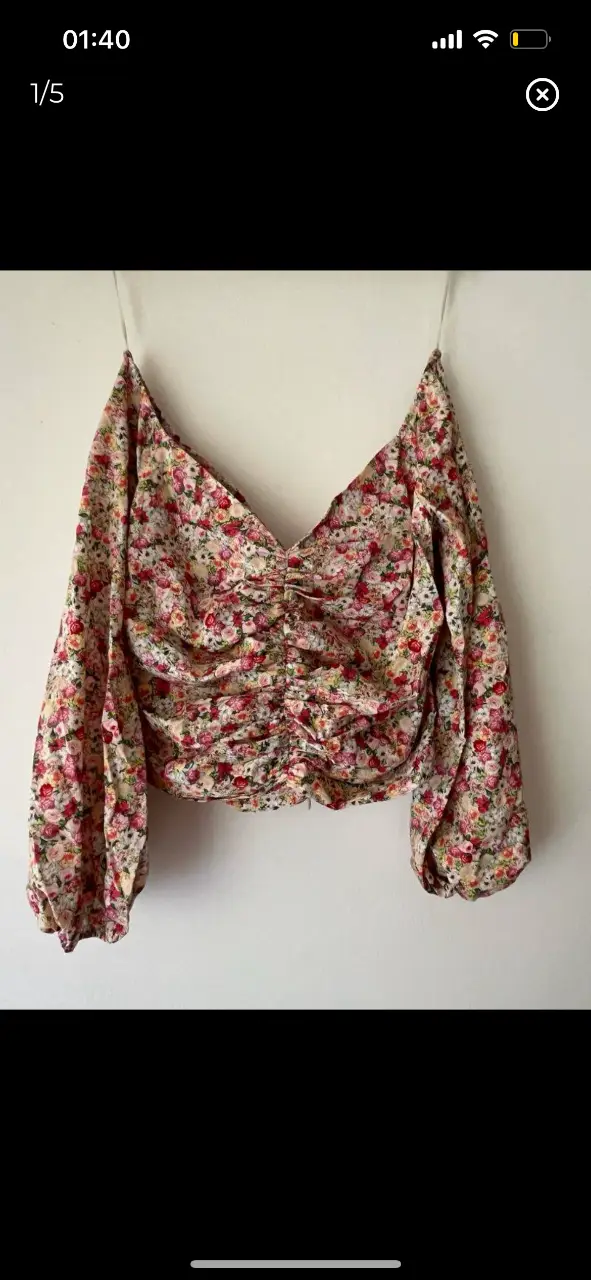 Blusa floreada con mangas largas de princesa y frunce por delante en la línea del escote cierre escondido en la parte de atrás. Ideal para un look romántico y femenino.