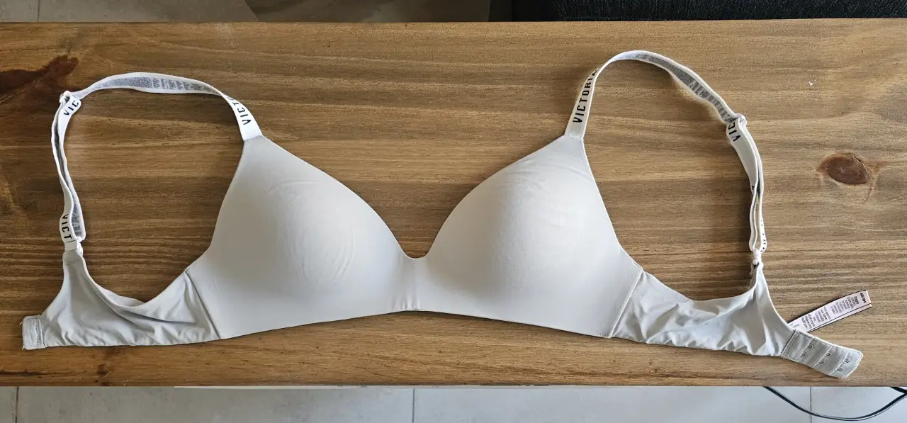 Corpiño Victoria's Secret, color gris claro, con tiras ajustables y logo de la marca en las mismas. Talle 34B/75.