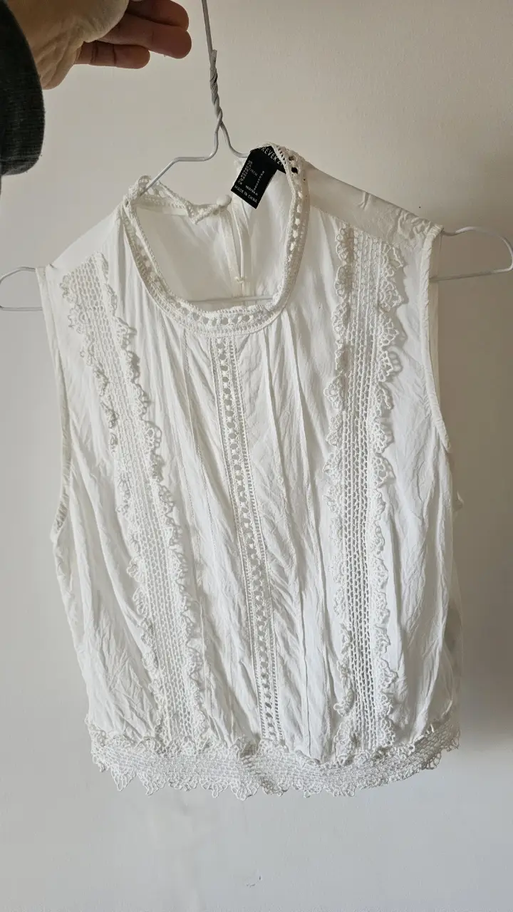 Crop top blanca con detalles de encaje, ideal para un look romántico y fresco. Perfecta para combinar con jeans o faldas.