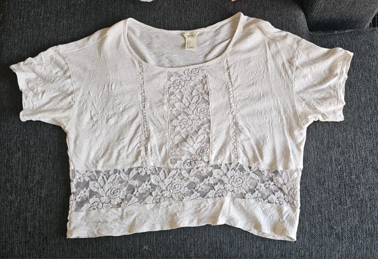 Crop top de mujer Forever 21 blanca con detalles de encaje. Ideal para un look casual y fresco.