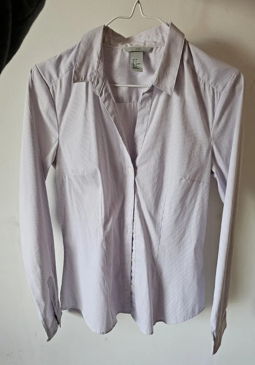 Camisa de mujer a rayas en tonos lila y blanco, de la marca H&M. Ideal para un look formal o de trabajo. Talle 6.