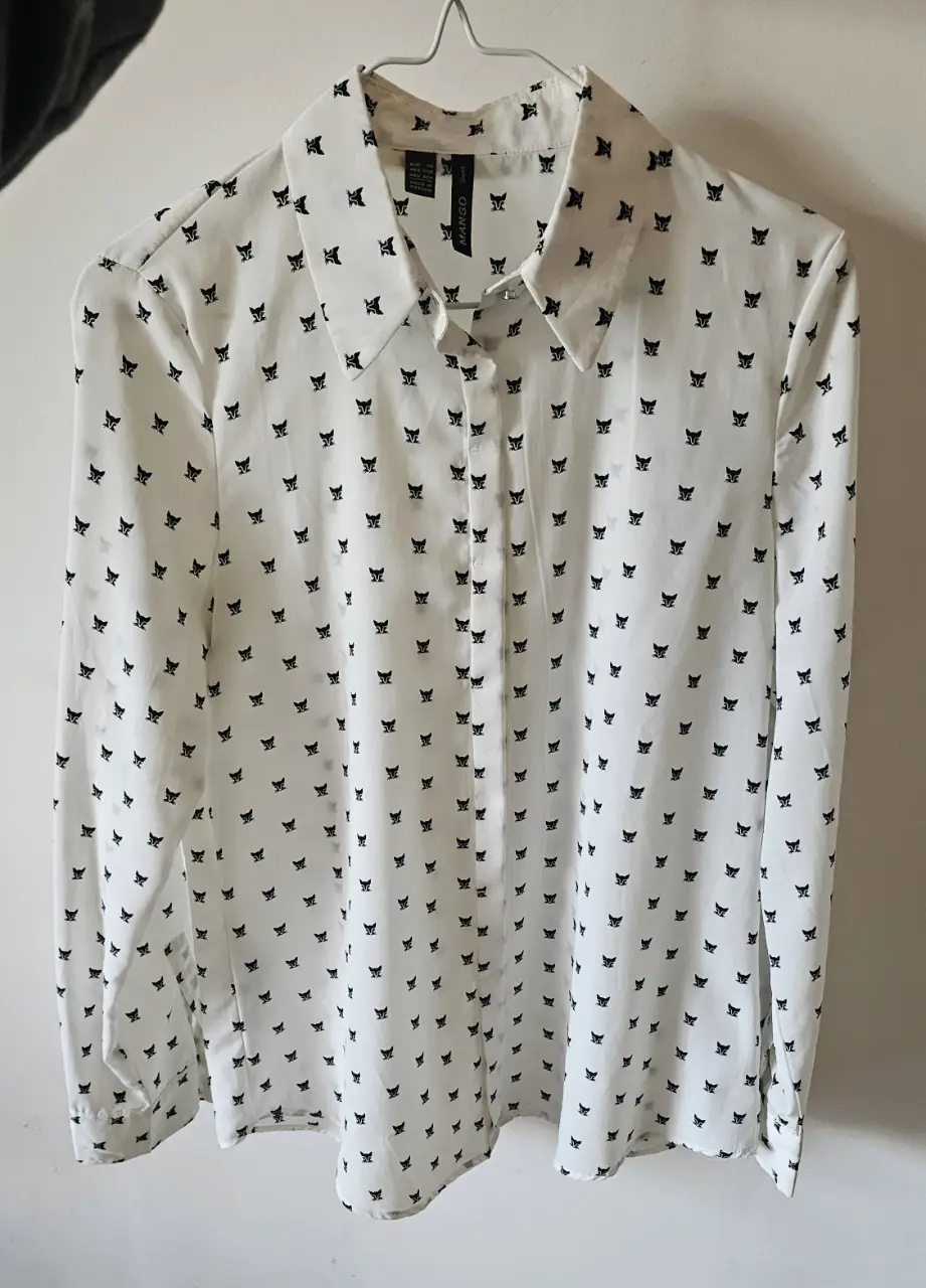 Blusa de mujer con estampado de gatos en blanco y negro. Manga larga, cuello camisero y cierre frontal con botones. Ideal para un look casual y elegante. Marca xs pero es grande, para alguien s/m es perfecta. 