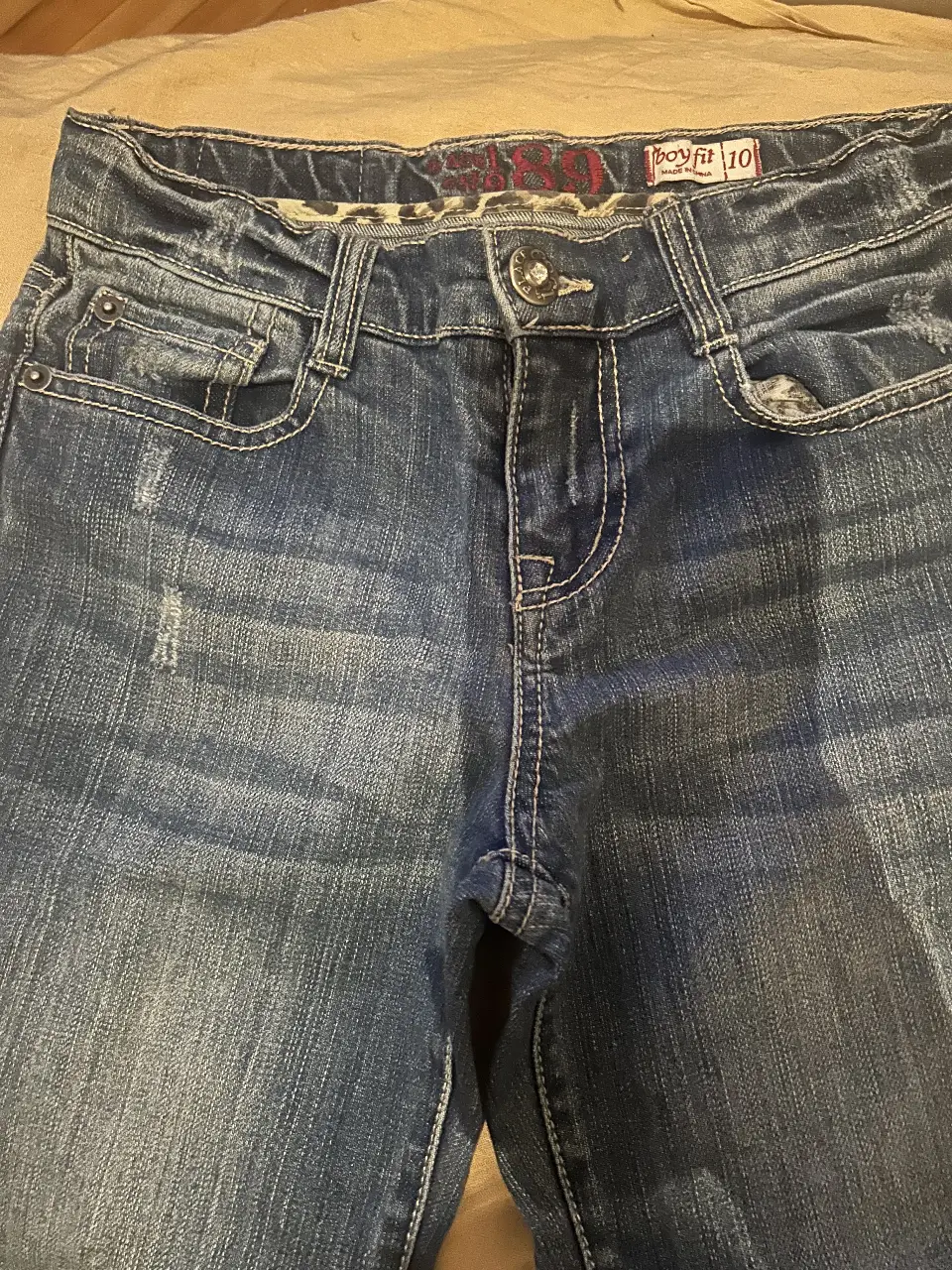 Jeans de mujer, tiro medio, corte recto, con detalles de desgaste y roturas. Talle 10.