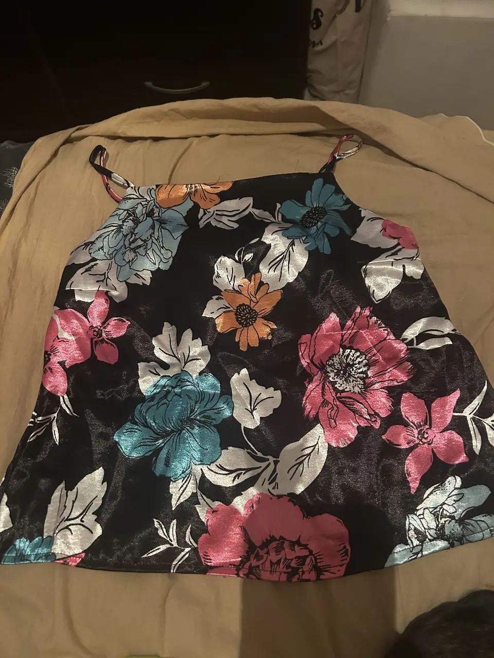 Top de satén negro con estampado floral multicolor. Ideal para un look fresco y femenino.