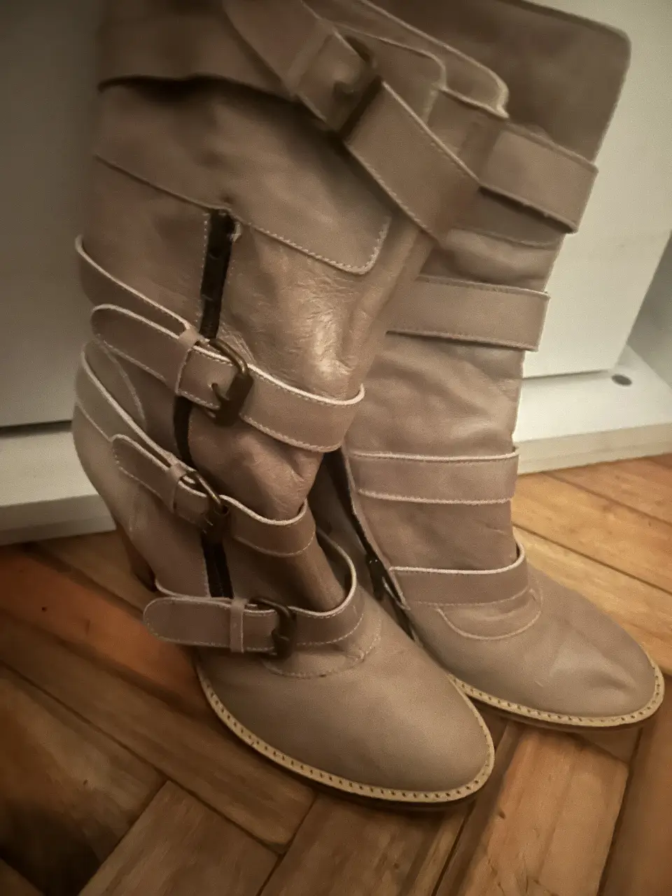Botas de caña alta color crudo con hebillas y cierre lateral. Ideales para un look moderno y canchero.