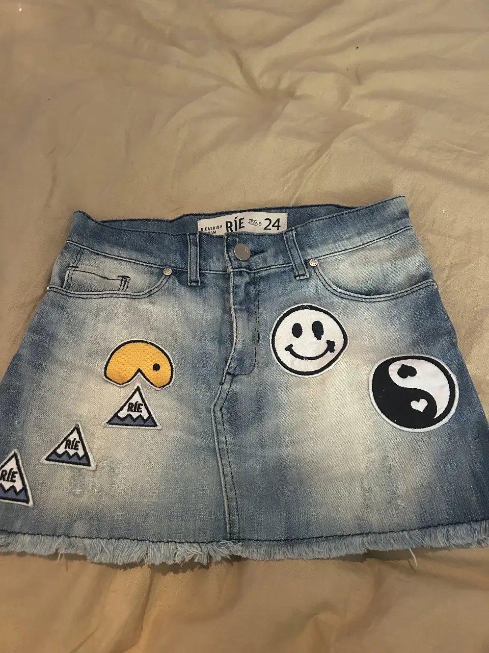 Minifalda de jean azul con parches decorativos. Talle 24. Ideal para un look casual y juvenil.