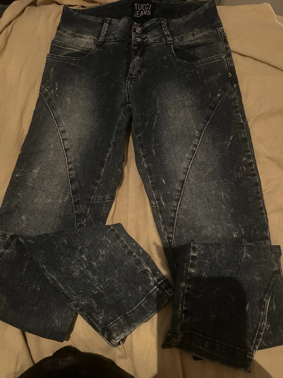 Jeans de mujer tiro alto, con diseño en las piernas y detalles gastados. Marca Tucci Jeans.