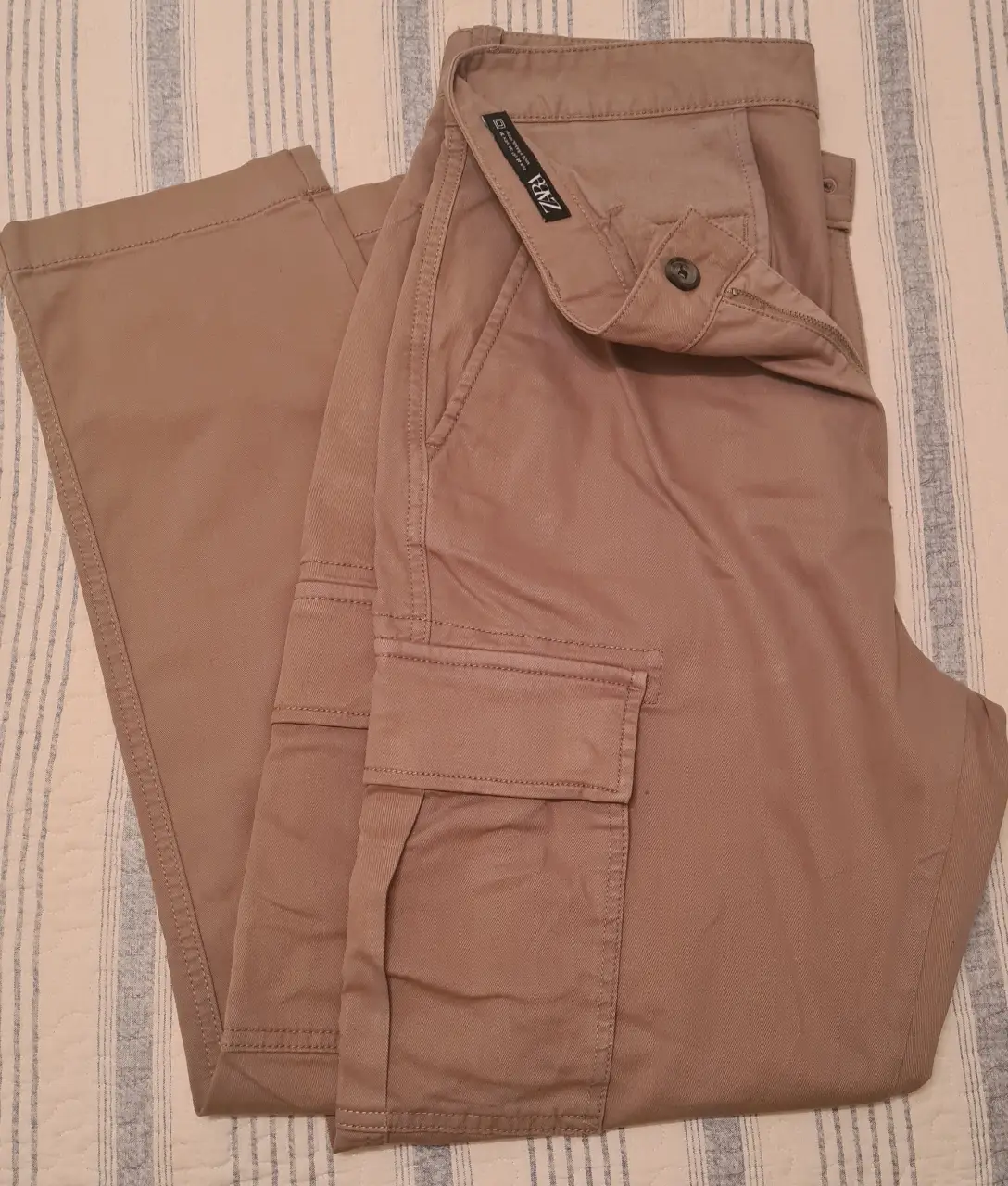 Pantalón cargo color khaki de hombre, con bolsillos laterales y cierre con botón. Ideal para un look casual y funcional.