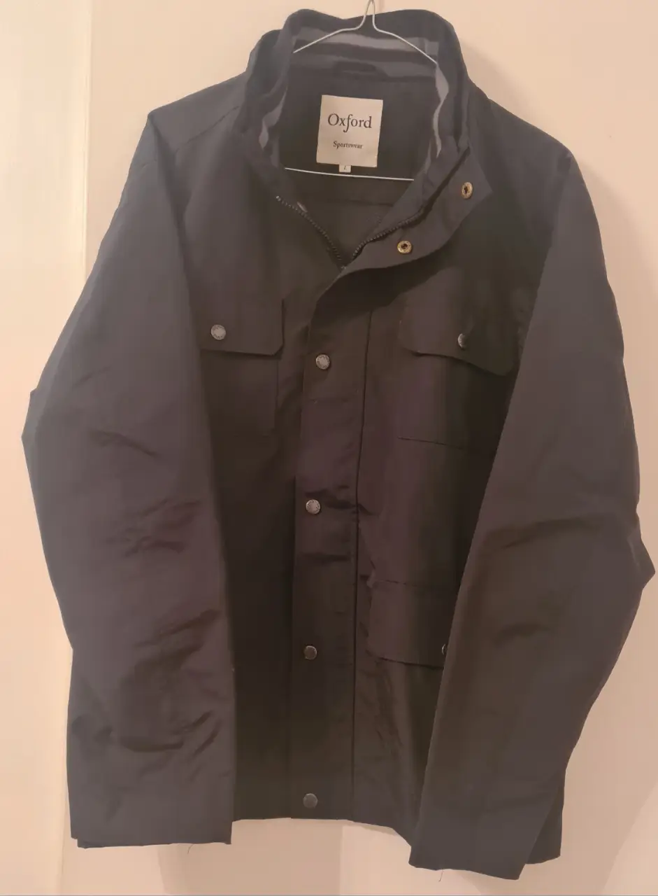 Campera Oxford Sportswear negra, ideal para el invierno. Con bolsillos y botones.